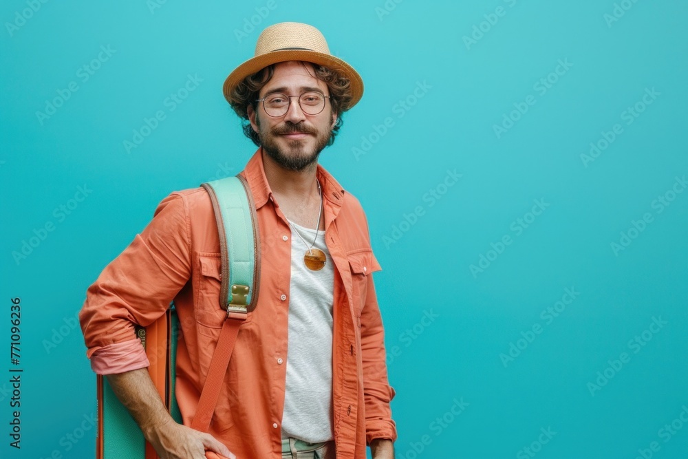 Young caucasian man over isolated background in vacation with travel suitcase and a hat Young caucasian man over isolated background in vacation with travel suitcase and a hat