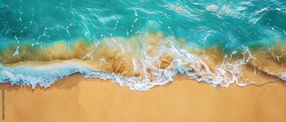 Gentle white sea foam spreads across the warm sandy shore in this calming top-down ocean view