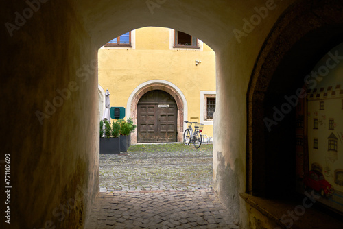 Old Arched Doorway in Europe. A doorway onto a lane at the end of a passageway in a historic medieval European town.

