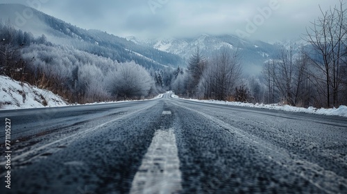 Wintry road leading through a snow-covered landscape towards mountains, Concept of winter journey and natural beauty 