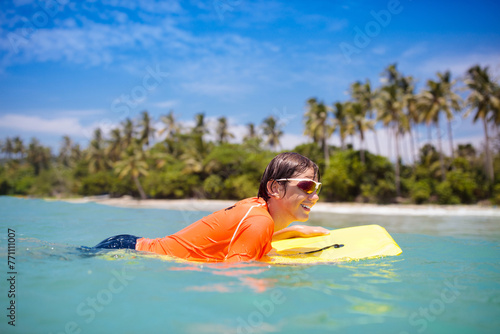 Photography Child surfing on tropical beach. Surfer in ocean.