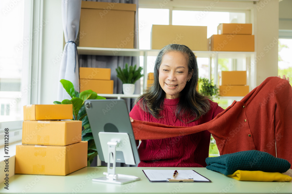 Happy mature businesswoman, small business owner in warehouse office There are parcel boxes piled up in the back, retail stores, individual entrepreneurs. Selling products online, SME business idea