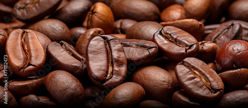 Macro photography of a pile of coffee beans, a key ingredient in many cuisine recipes. The natural food staple is showcased against a rustic wood backdrop