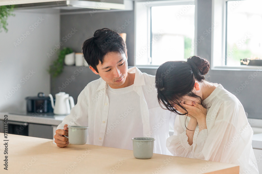 ダイニングで落ち込む・泣く女性・妻・彼女を慰める男性・夫・彼氏（喧嘩・夫婦喧嘩）

