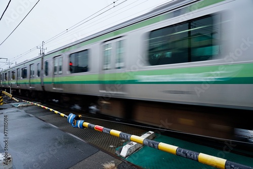 鉄道の踏切、電車が流れて行く