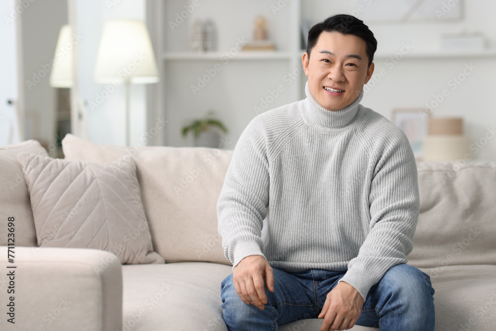 Portrait of smiling man on sofa indoors. Space for text Portrait of smiling man on sofa indoors. Space for text