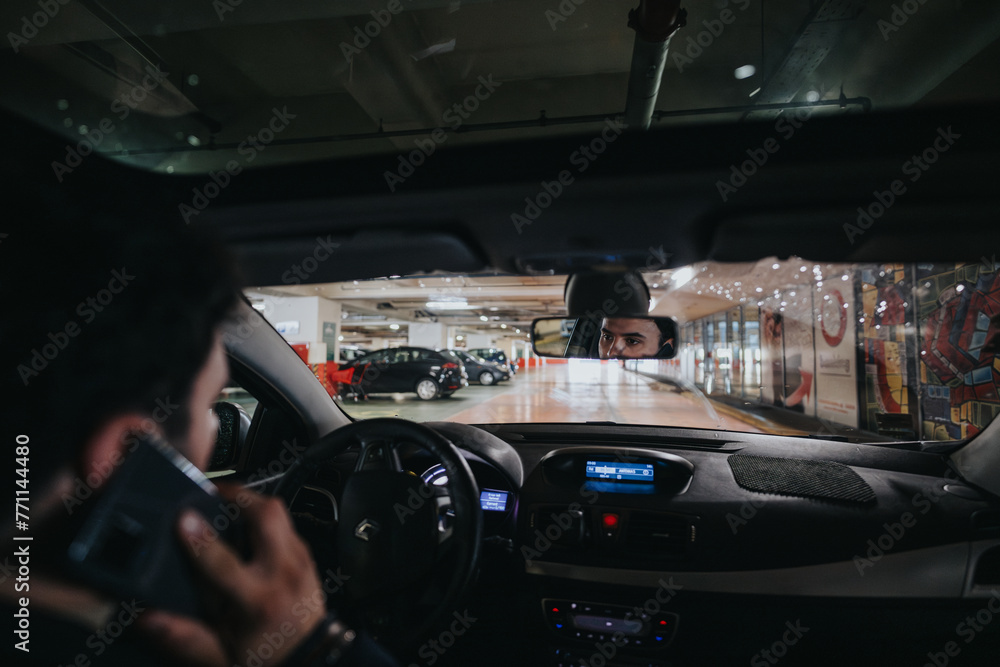 Focused young man using his phone while driving inside a parking garage, highlighting the dangers of distracted driving. Focused young man using his phone while driving inside a parking garage, highlighting the dangers of distracted driving.