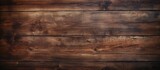 A closeup of a rectangular brown hardwood table with wood stain and a beautiful pattern, set against a blurred background