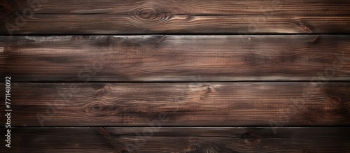 A closeup shot of a brown hardwood table with a rich wood stain, showcasing the intricate pattern of the wood plank. The blurred background highlights the beauty of the natural lumber