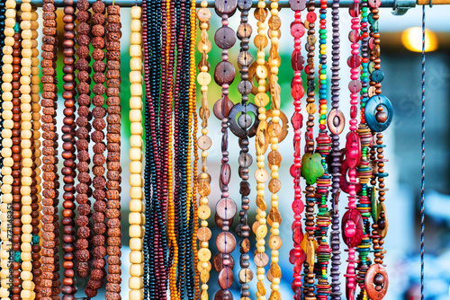 Colorful necklaces at outdoor small souvenir shop in Italy. Decorative colorful crystal chaplets as background. Beautiful bright beads. Decorative ornaments for women.