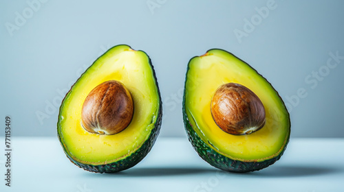 Close-up of an avocado on a gray background. Bright vegetable. Two halves of an avocado. Food concept, healthy lifestyle.