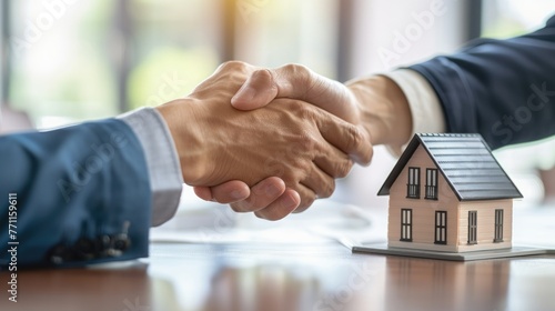 Professional real estate agent shaking hands with client after signing home purchase contract in real estate agency office