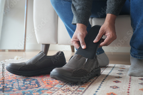 men hand putting Orthopedic insoles in shoes  © Towfiqu Barbhuiya 