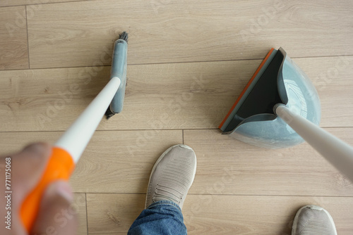 top view of men suing floor dust with dust pan  photo