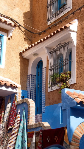 Colorful textiles hanging in front of the entrace to a house in the medina, in Chefchaouen, Morocco photo