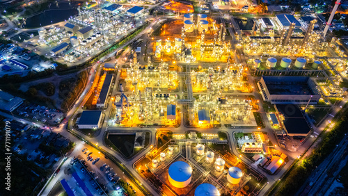 Oil refinery plant industry and port, Aerial view oil and gas petrochemical industrial, Refinery factory oil storage tank and pipeline steel at night, Ecosystem and healthy environment concepts.