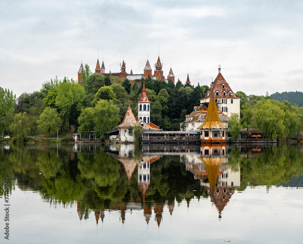 A group of ancient castle -style buildings are built in a small hillside forest, with a large lake outside, in a park in Deyang, China A group of ancient castle -style buildings are built in a small hillside forest, with a large lake outside, in a park in Deyang, China
