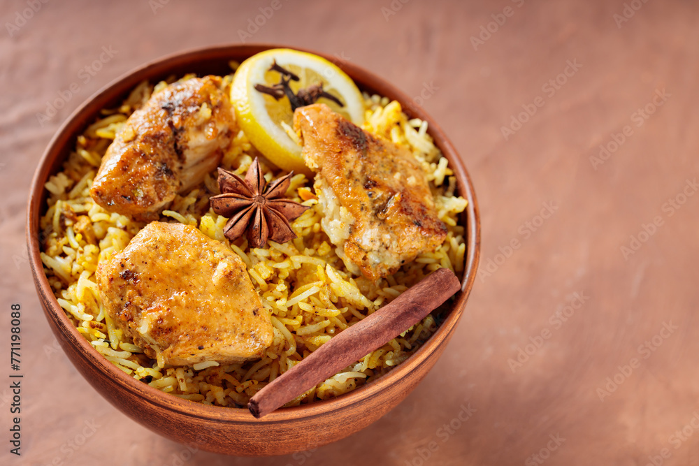 Chicken Biryani with Fried Chicken, Spices and Lemon on Brown Background, Top View, Copy Space Chicken Biryani with Fried Chicken, Spices and Lemon on Brown Background, Top View, Copy Space