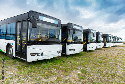 Many electric driven new energy buses are neatly parked in outdoor parking lots
