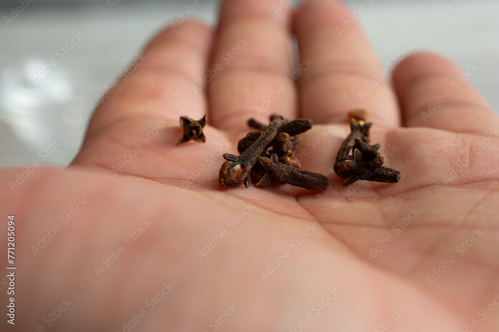 A closeup view of several cloves in the palm of a hand.