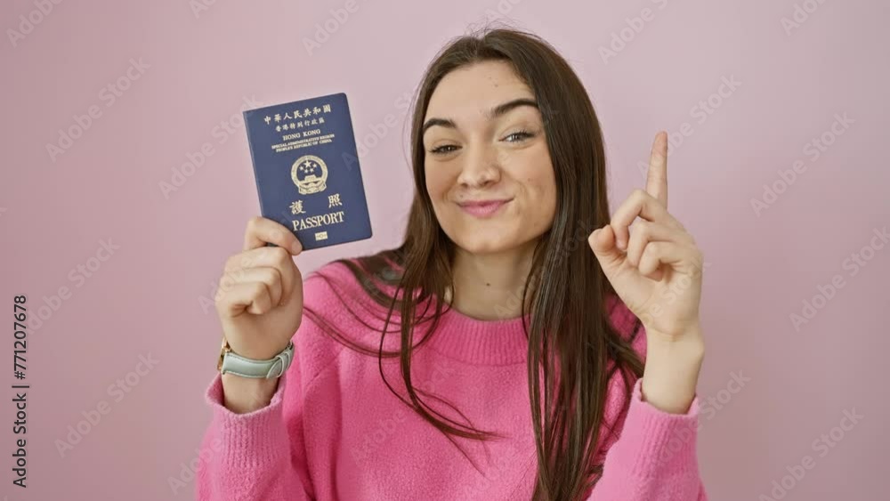 Happy, young hispanic woman holding hong kong passport, comes up with smart idea! confident expression, finger points to 'number one'. isolated over pink background. Happy, young hispanic woman holding hong kong passport, comes up with smart idea! confident expression, finger points to 'number one'. isolated over pink background.