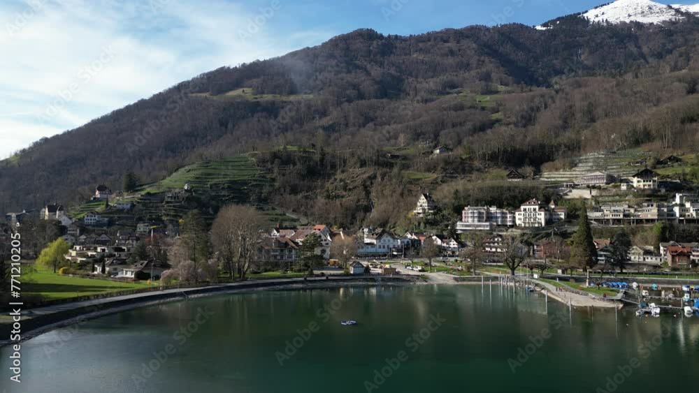 Drone clip showing view of traditional white buildings on shore of calm lake, with snow topped mountains in the background Drone clip showing view of traditional white buildings on shore of calm lake, with snow topped mountains in the background