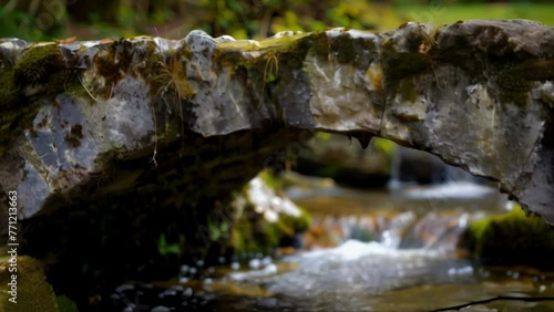 An old stone bridge spans a gurgling stream its cracked and mosscovered surface serving as a reminder of the countless journeys taken . AI generation. photo