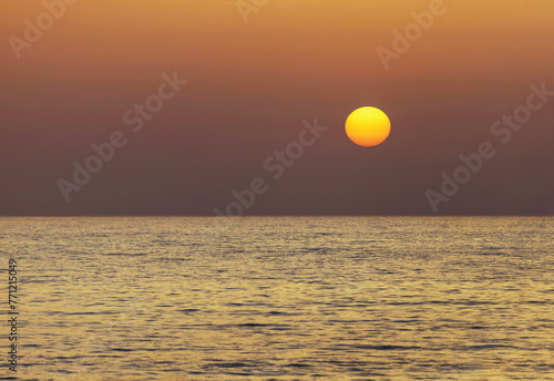  yellow-red circle of sun over the sea at sunset