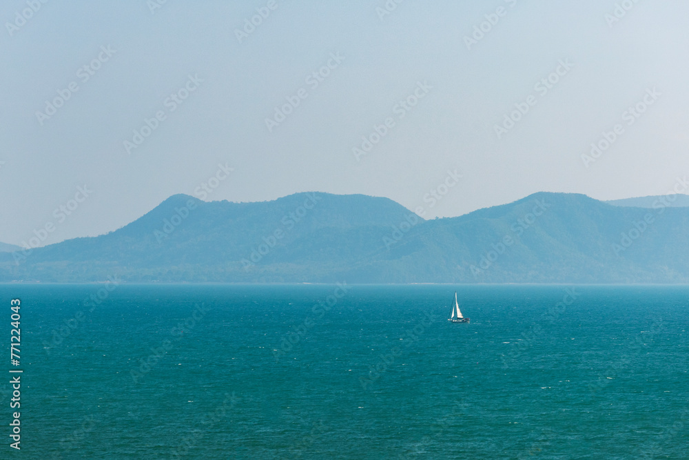 A lonely sailing boat floating in the ocean. Concept of freedom, tropical vacation, sailing, adventure. A lonely sailing boat floating in the ocean. Concept of freedom, tropical vacation, sailing, adventure.