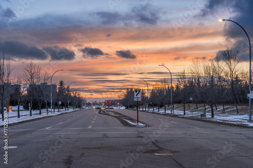 Sunset landscape in city of Edmonton with light snow cover and red and yellow traffic lights
