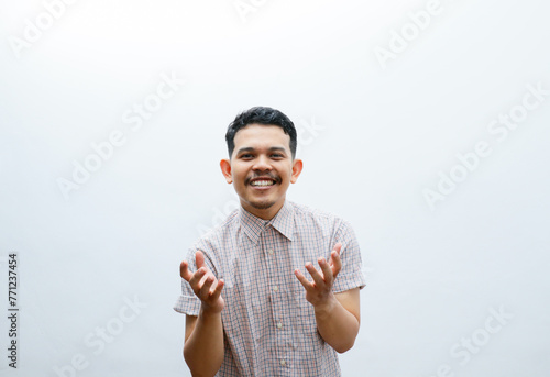 Adult Asian man smiling happy with both hand doing giving something pose photo