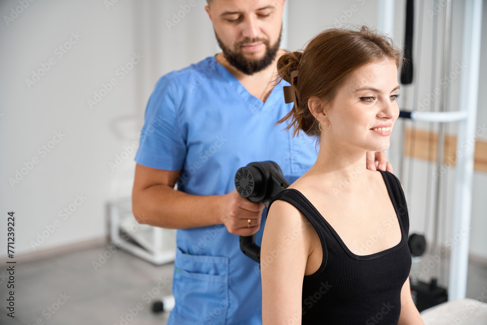 Doctor massages a patients back with a special massager Doctor massages a patients back with a special massager