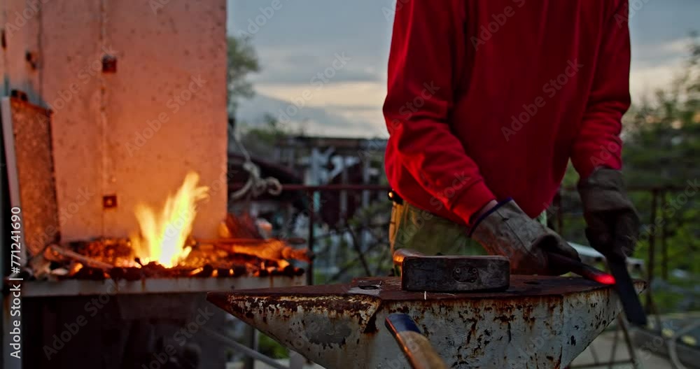 Blacksmith Forging Hot Metal By Scraping Outdoor. medium shot