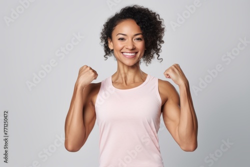 Mixed race sporty woman showing off biceps.