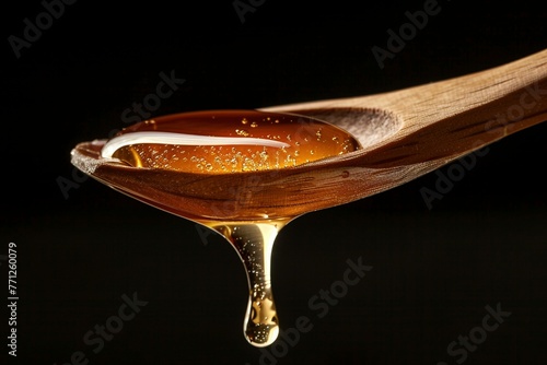 Honig auf einem Holzlöffel, schwarzer Hintergrund  © Herzog