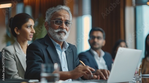 Successful Indian CEO Making a Presentation on a Laptop to a Board of Directors During a Corporate Meeting. South Asian Business Partners Discussing International Markets