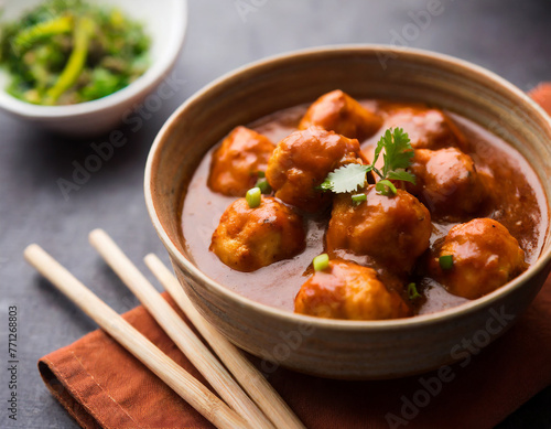 veg or chicken manchurian with gravy popular food of india served in a bowl with chopstick photo