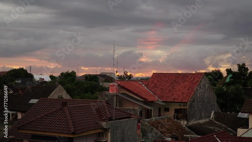 Timelapse of beautiful sunlight behind clouds in the afternoon at a housing estate photo
