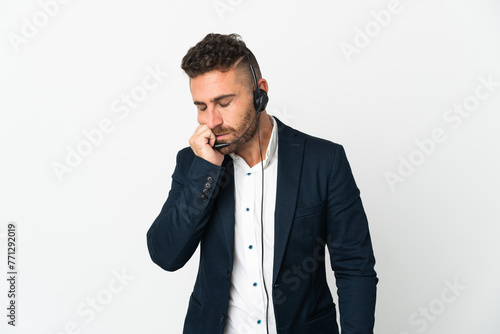 Telemarketer man working with a headset isolated on white background having doubts