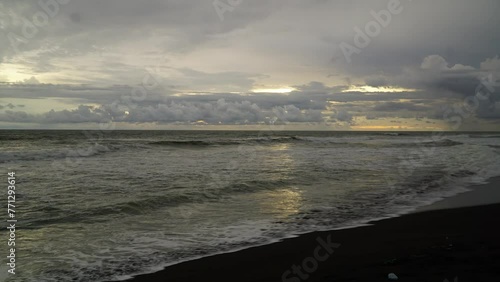 Timelapse before dark skies on a black sand beach photo