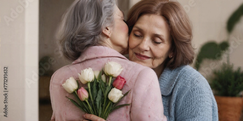 An old mother and her mother hugging with flowers. A mother's day celebration for older mothers or grandmother's day.