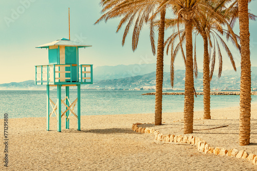 Lifeguard tower on the beach with palmtrees in the summer photo