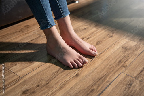 Barefoot woman walking on floor at home. © andranik123