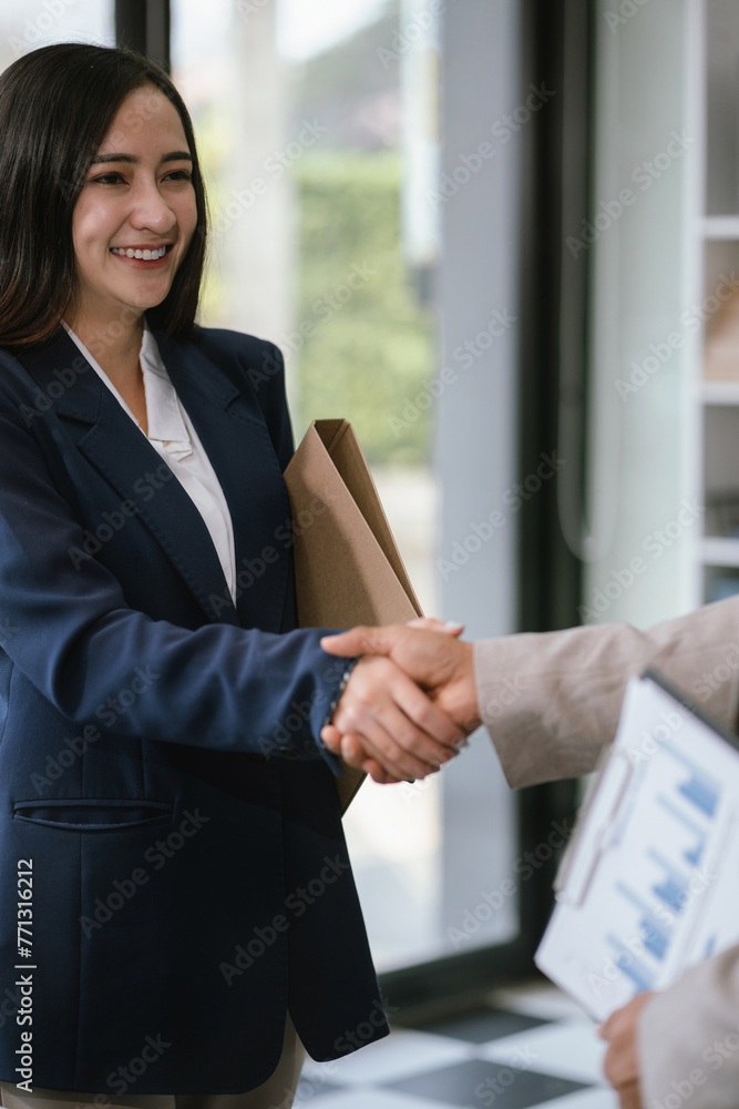Happy businessman and businesswoman shaking hands at group board meeting. Happy businessman and businesswoman shaking hands at group board meeting.