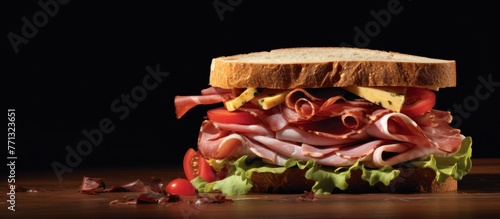 A detailed view of a sandwich filled with assorted meats and fresh vegetables placed on a rustic wooden table, highlighting succulent deli ham slices