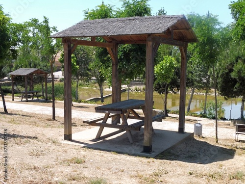 Typical picnic area with a wooden table and bench and a shade roof in Spain