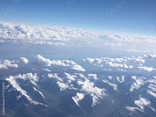 Obraz na płótnie An aerial view of blue sky, white clouds and snow-capped mountains
