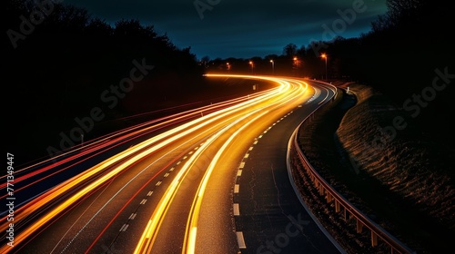 A long road with a bright yellow line on it. The road is wet and the lights are on
