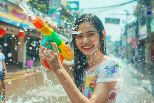 Happy traveler asian woman wearing summer shirt holding colourful squirt water gun over blur city, Water festival holiday concept