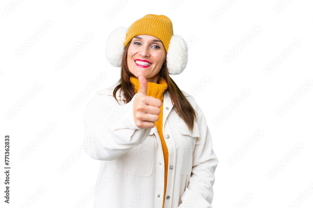 Middle age woman wearing winter muffs over isolated chroma key background with thumbs up because something good has happened Middle age woman wearing winter muffs over isolated chroma key background with thumbs up because something good has happened